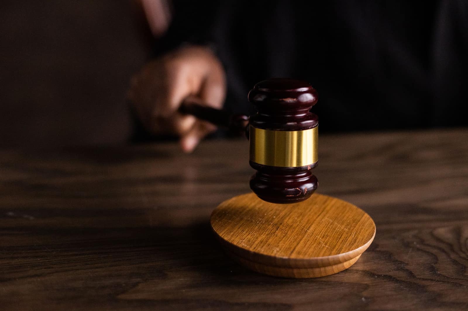 A wooden gavel resting on a sound block, symbolizing a courtroom