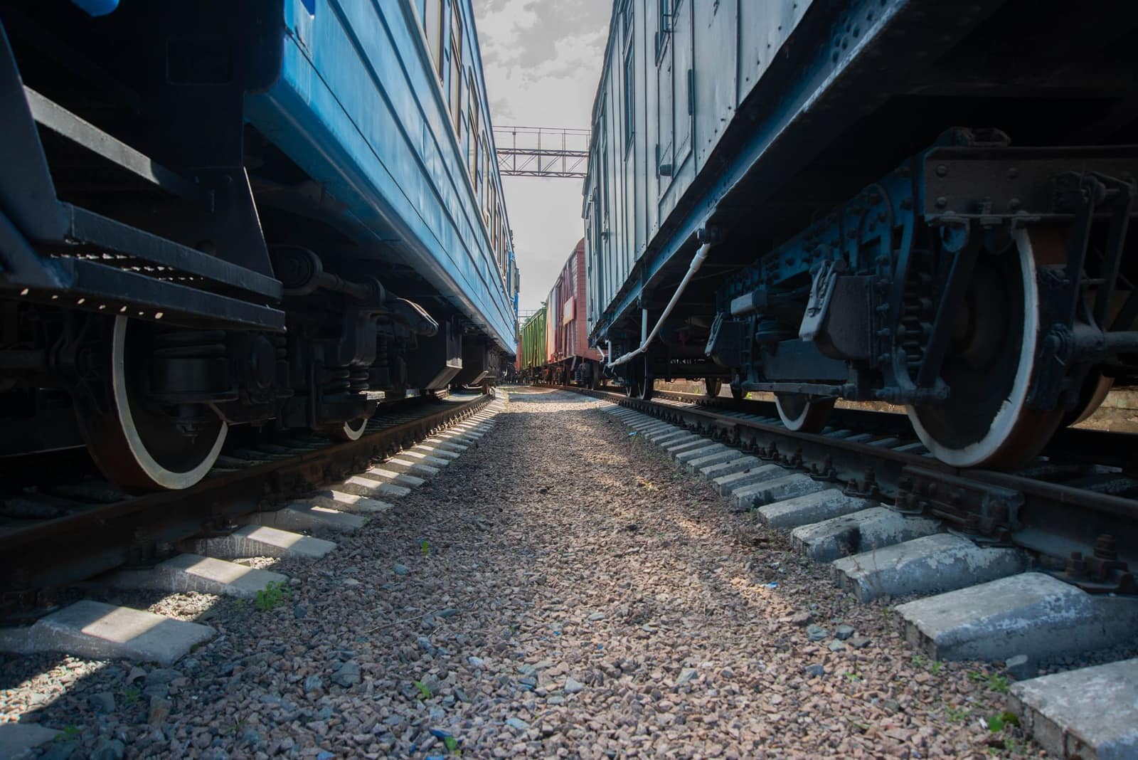 Close-up view of railway tracks running between two rail cars