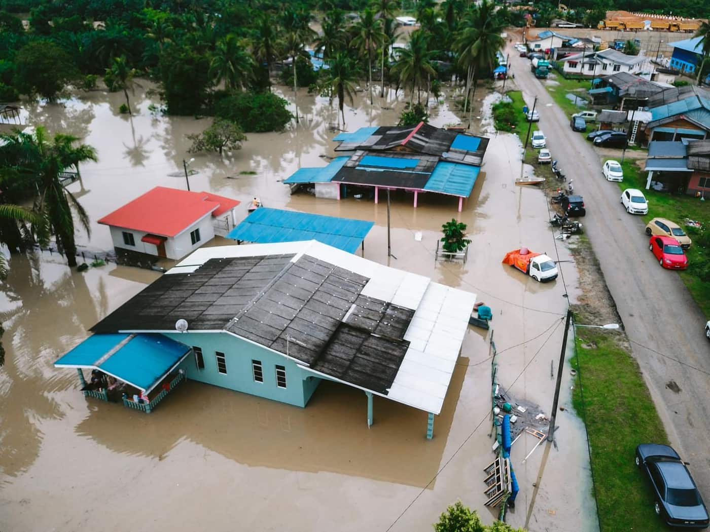 Aerial view of a flooded village with submerged houses and streets