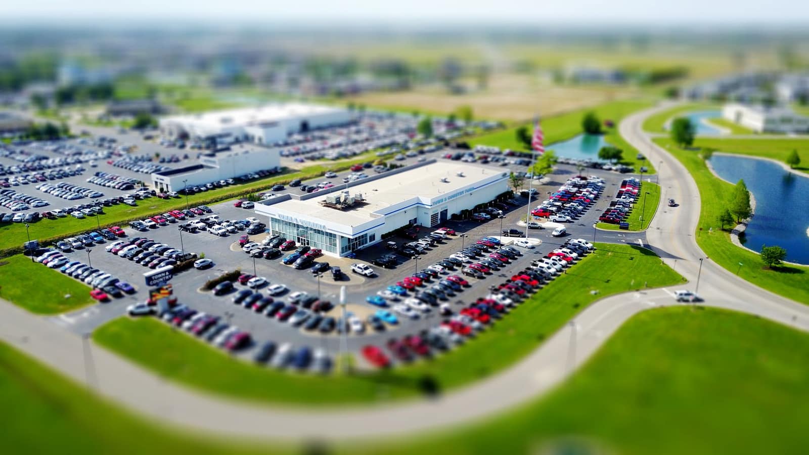 Aerial view of a car dealership lot with rows of parked vehicles
