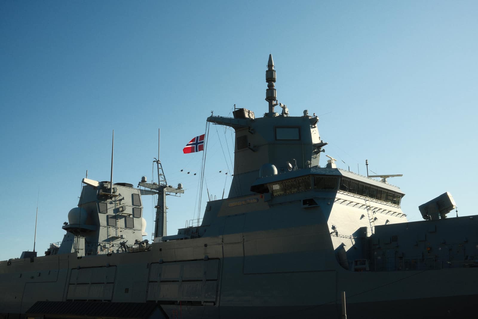 A naval warship with a flag at sea