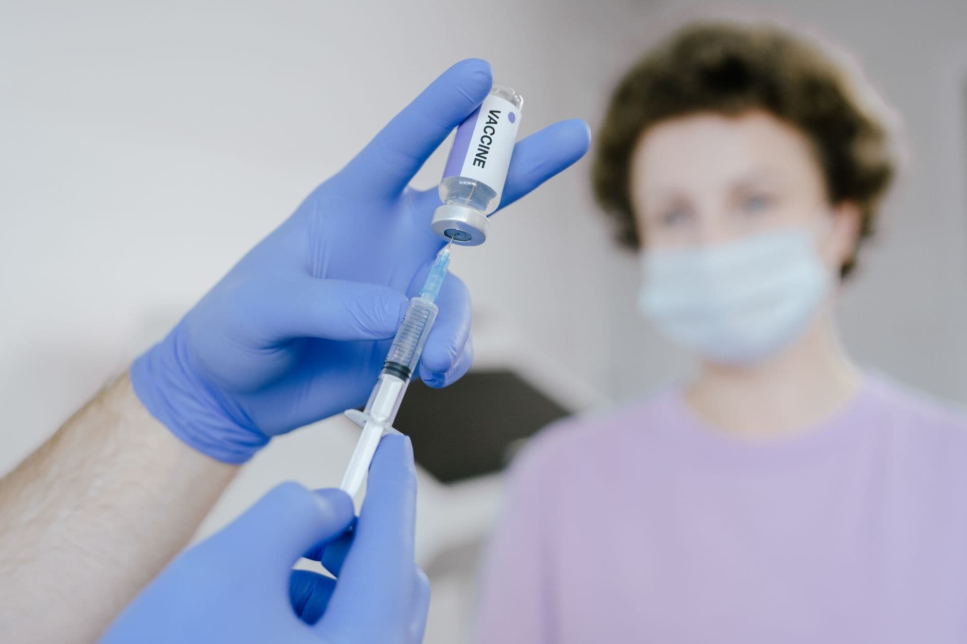 Close-up of a doctor's gloved hands holding a syringe