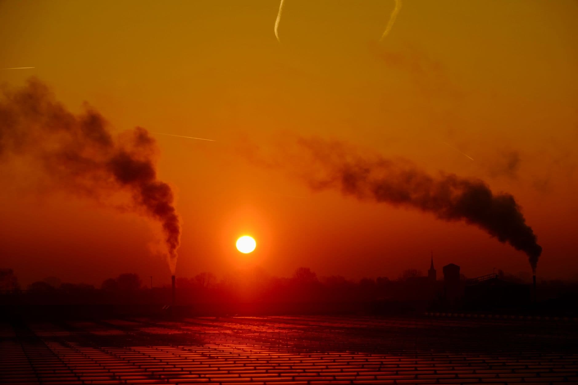 Sunset over an industrial landscape with smoke emissions