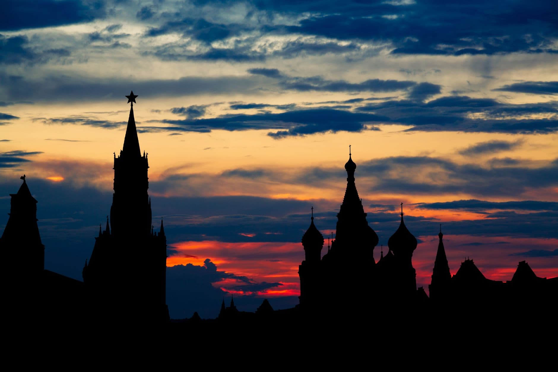 Dramatic silhouette of Moscow's Kremlin towers against a vivid sunset sky