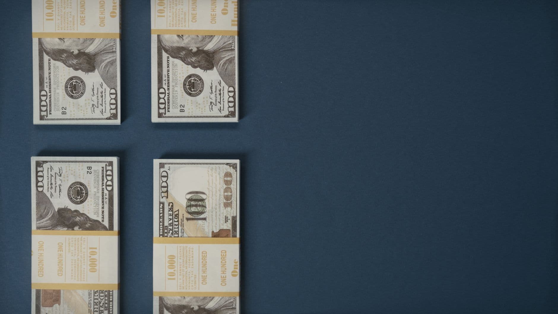 Bundles of US dollar banknotes stacked on a surface