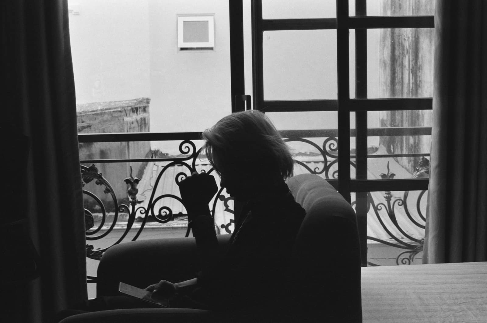 Silhouette of a person sitting indoors alone, deep in thought