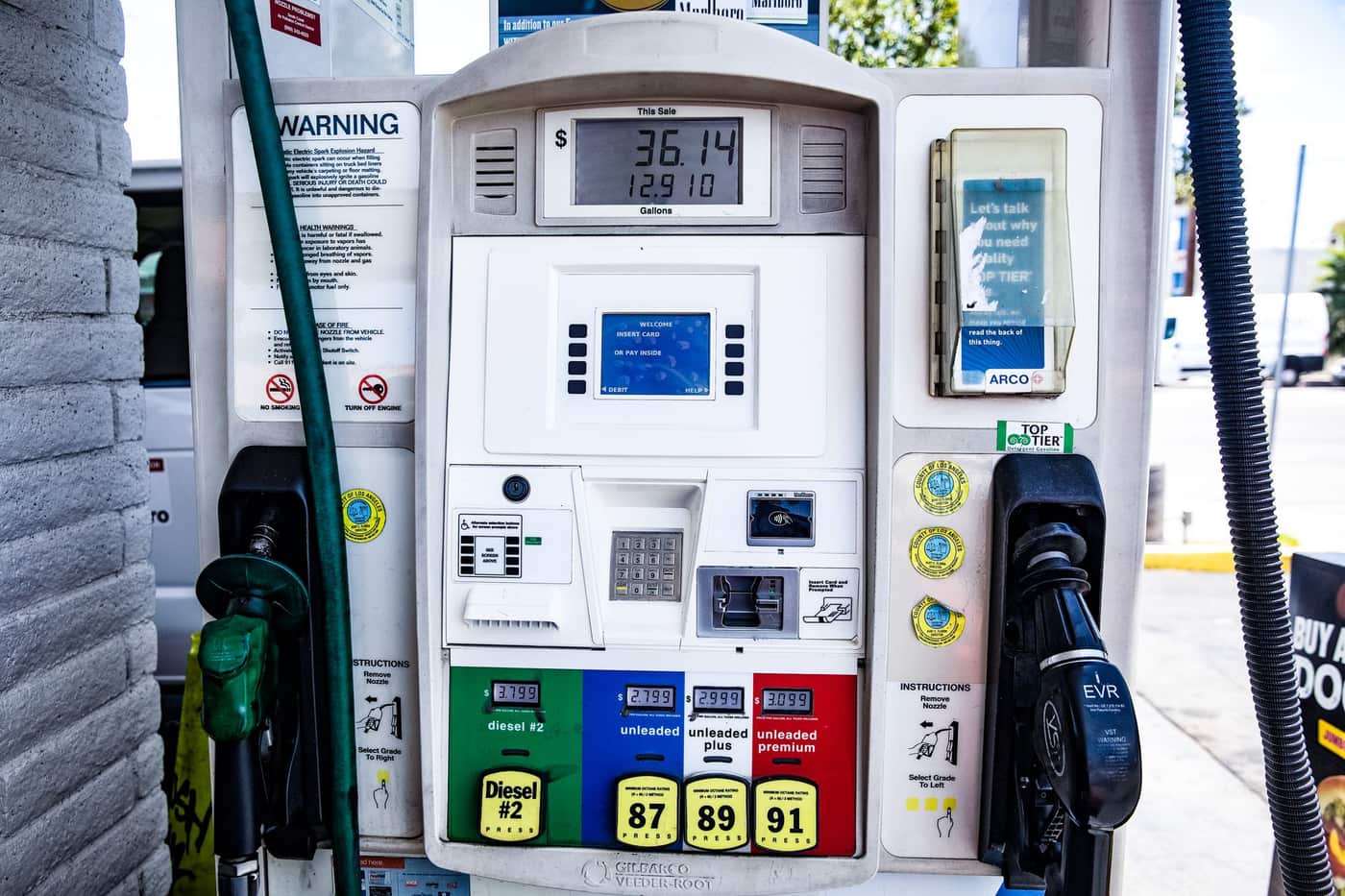Gasoline pump nozzle inserted into a car's fuel tank at a filling station