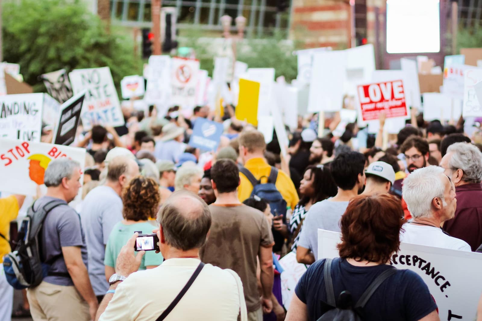 A crowd holding banners and placards together at an outdoor protest gathering