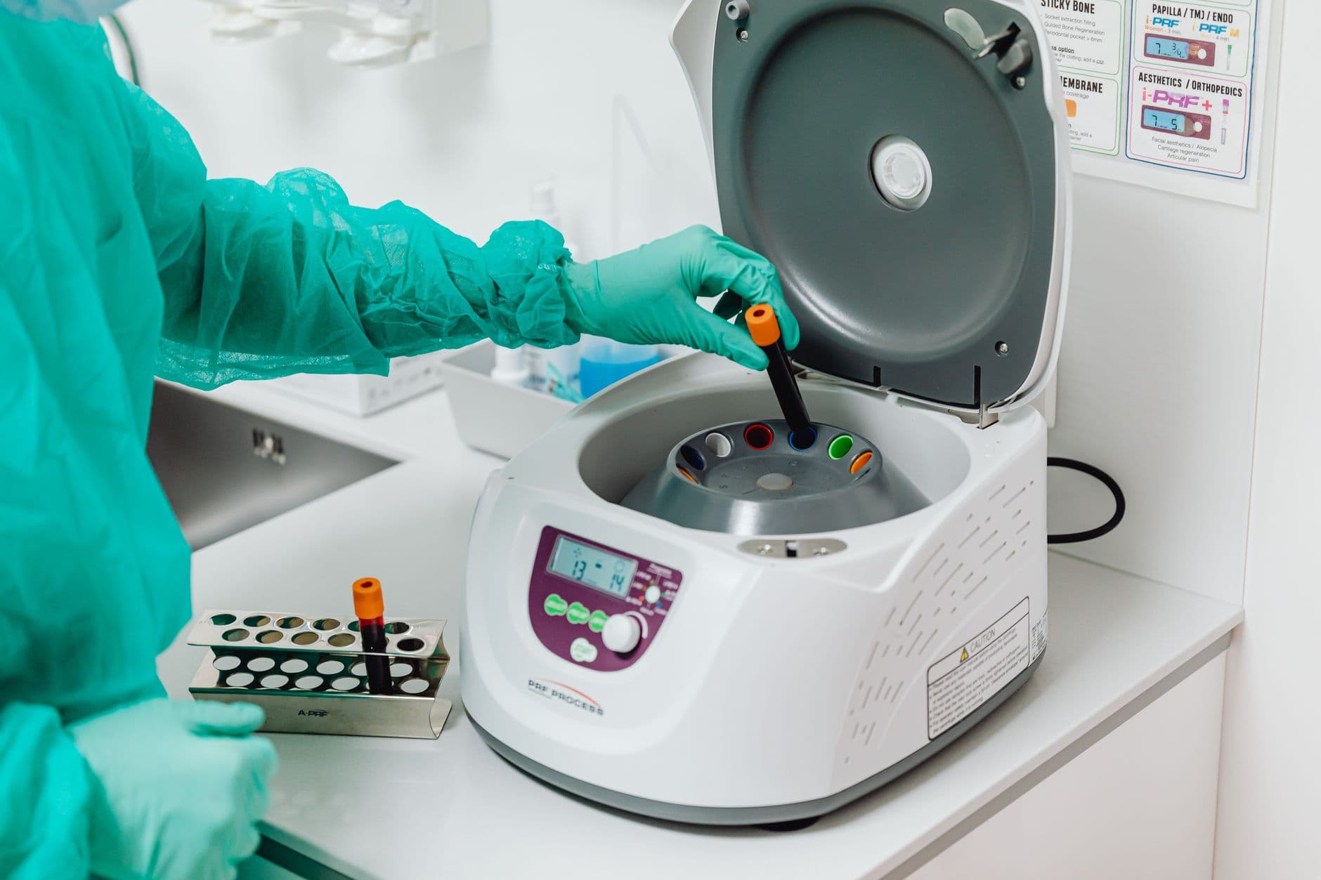 A healthcare professional operating a centrifuge machine in a medical laboratory