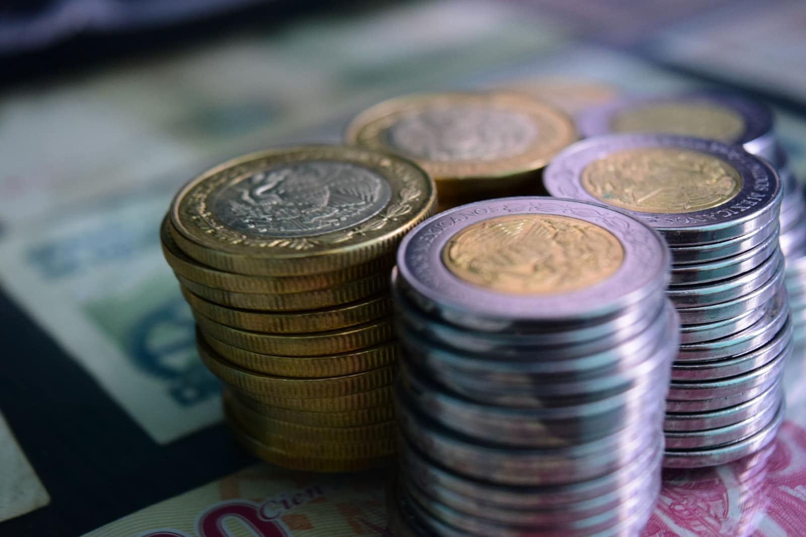 Stacked gold and silver coins resting on currency notes