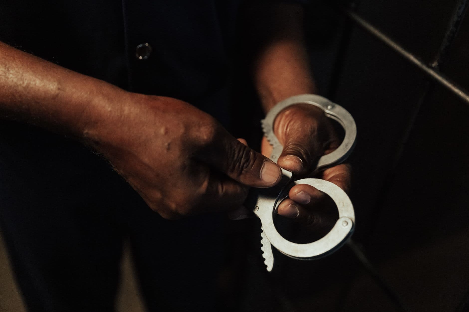 Close-up of hands holding a pair of handcuffs