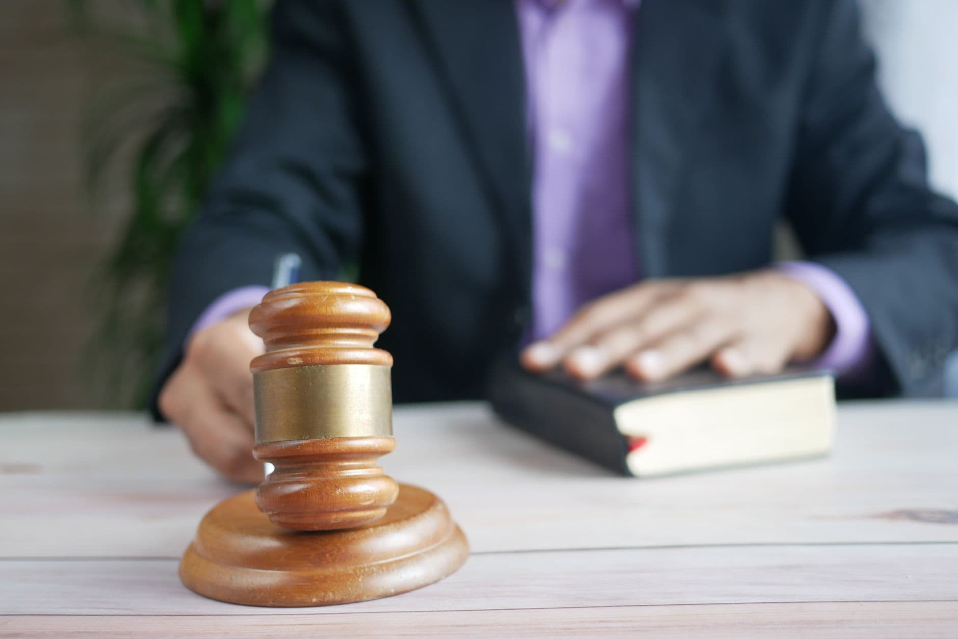 A wooden gavel resting on a legal book on a desk