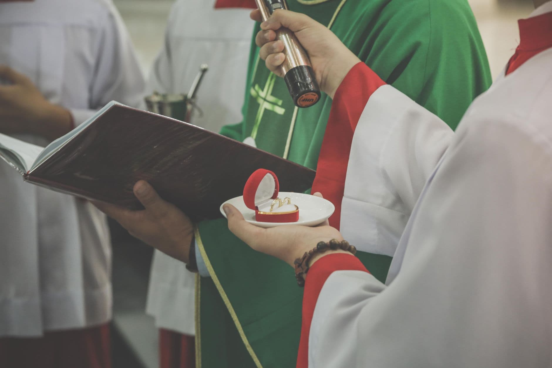 Intimate view of a wedding ceremony with rings held by a priest in a church