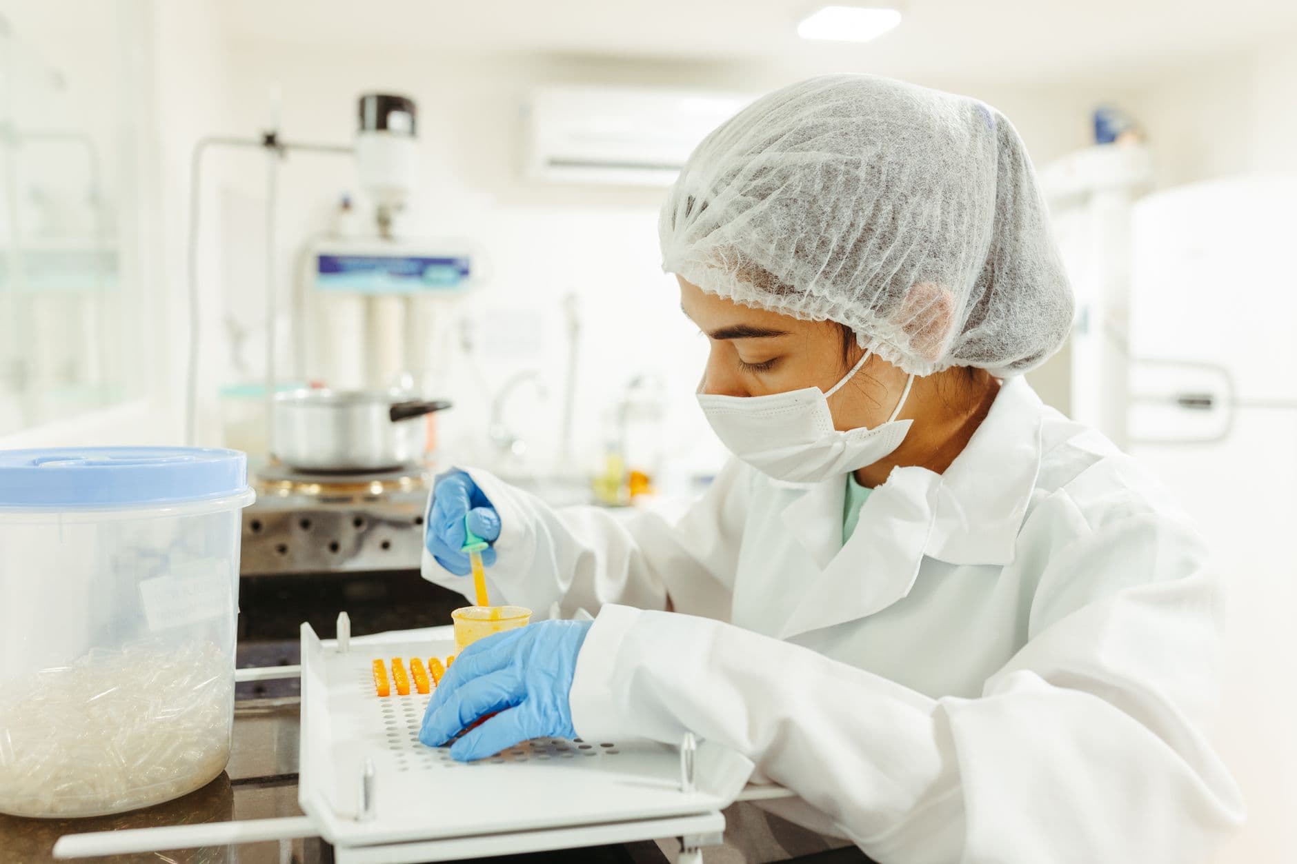 A scientist in protective gear performing a laboratory test
